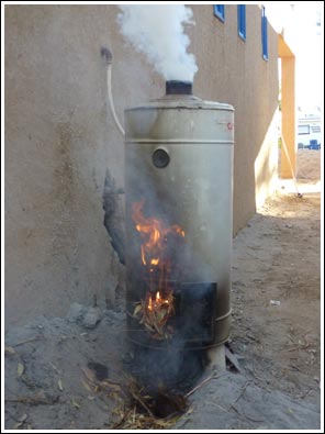 Opstoken van de waterboiler met palmbladeren